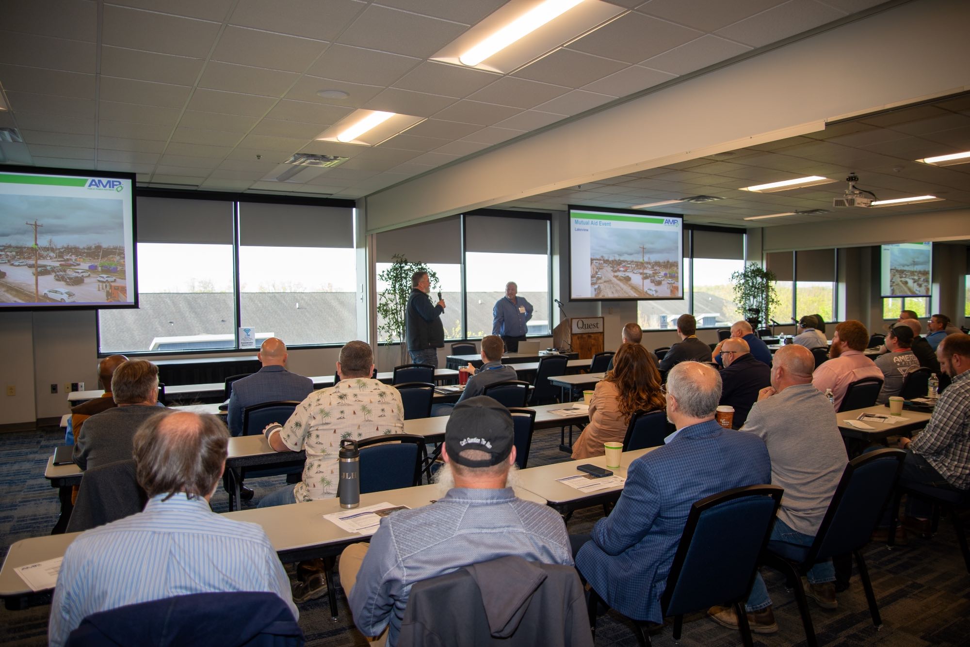 A room of conference attendees listening to a speaker at the AMP Technical Services Conference.